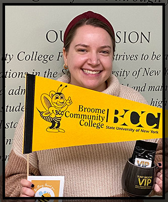 Brittney holds up her VIP items as she smiles