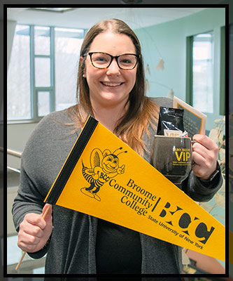 Justine smiles and holds her VIP gifts