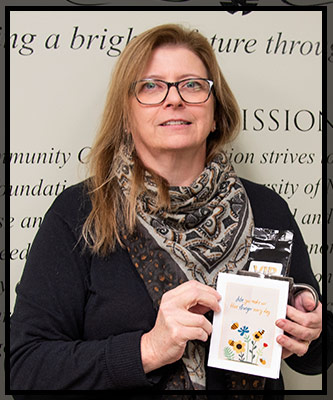 Julie smiles as she holds her VIP items