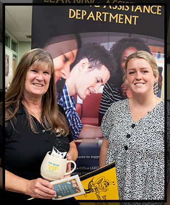 Lisa stands next to the LAD banner with her VIP gifts.