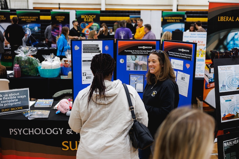 professor speaking with student at open house
