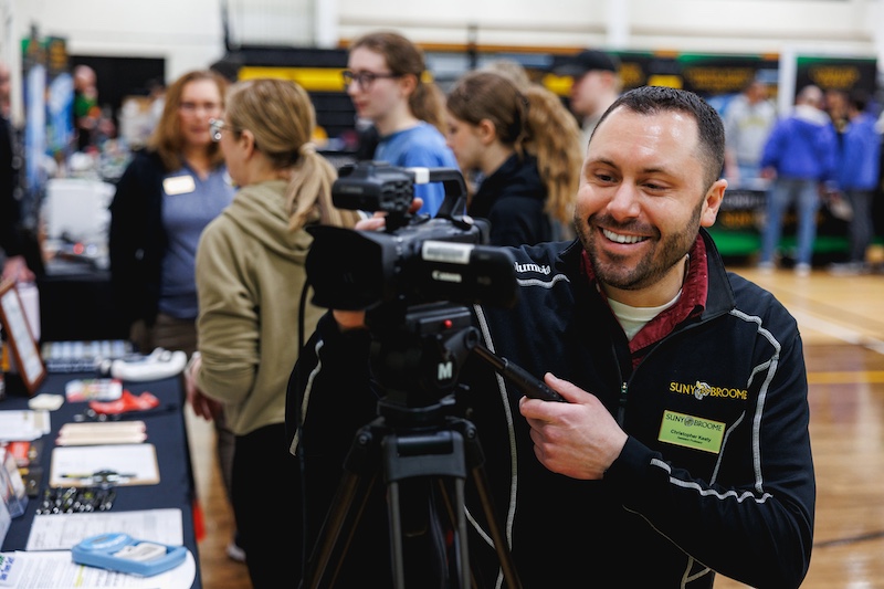 professor with camera at open house