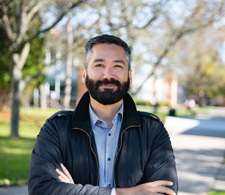 (Web)-Adult-Learner-Generic Teacher helping a student with his classwork in a library.