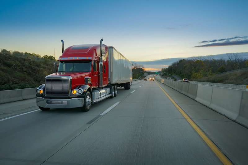 big red semi truck on highway